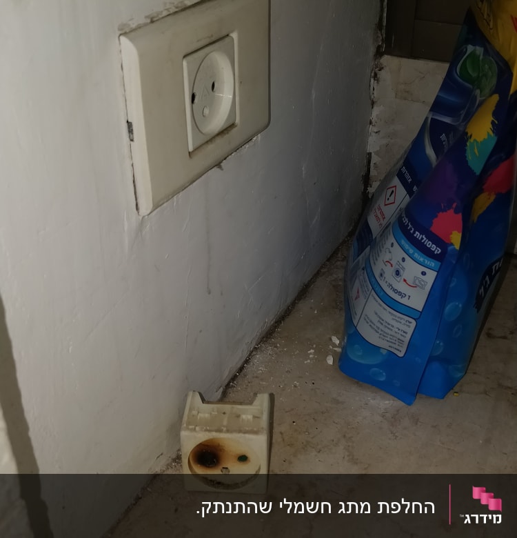 שקע חשמלי עם סימני שריפה וברגים על הרצפה